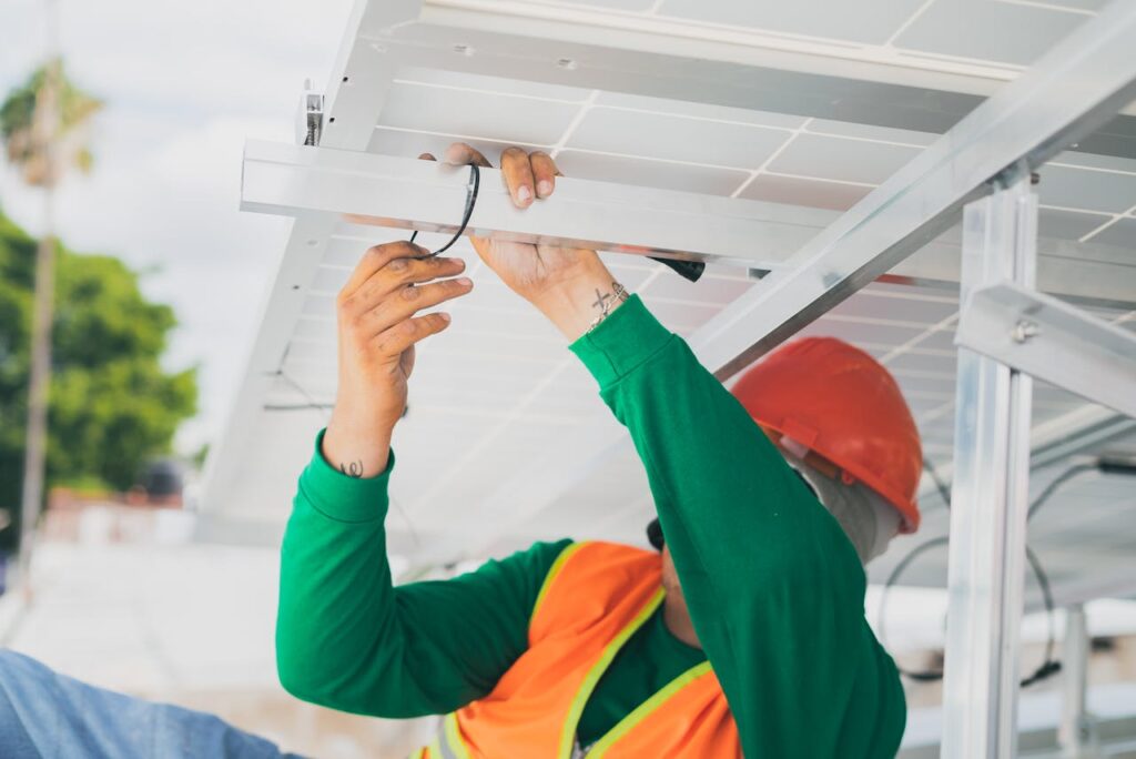 zipwp-image-8853525 A solar technician in PPE installs a solar panel, showcasing renewable energy work.